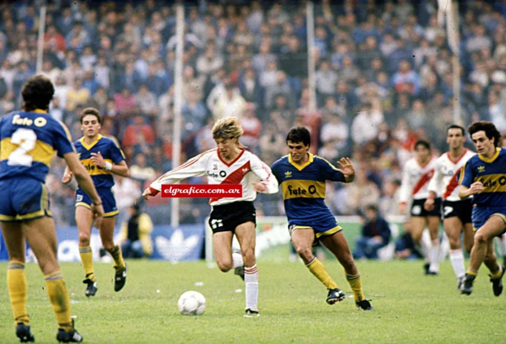 Hinchas de Boca Juniors desplegando banderas y tirando papelitos en La Bombonera durante un Superclásico contra River Plate.