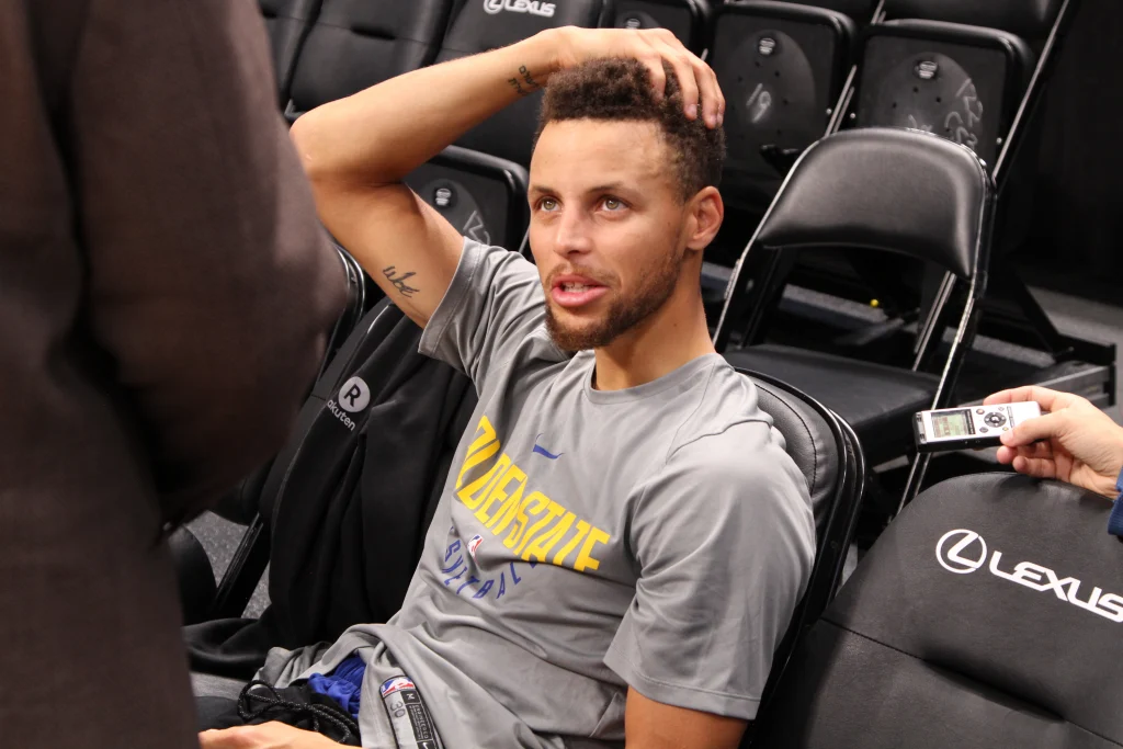 Stephen Curry de Golden State Warriors celebrando un triple sobre Luka Doncic de Los Angeles Lakers.